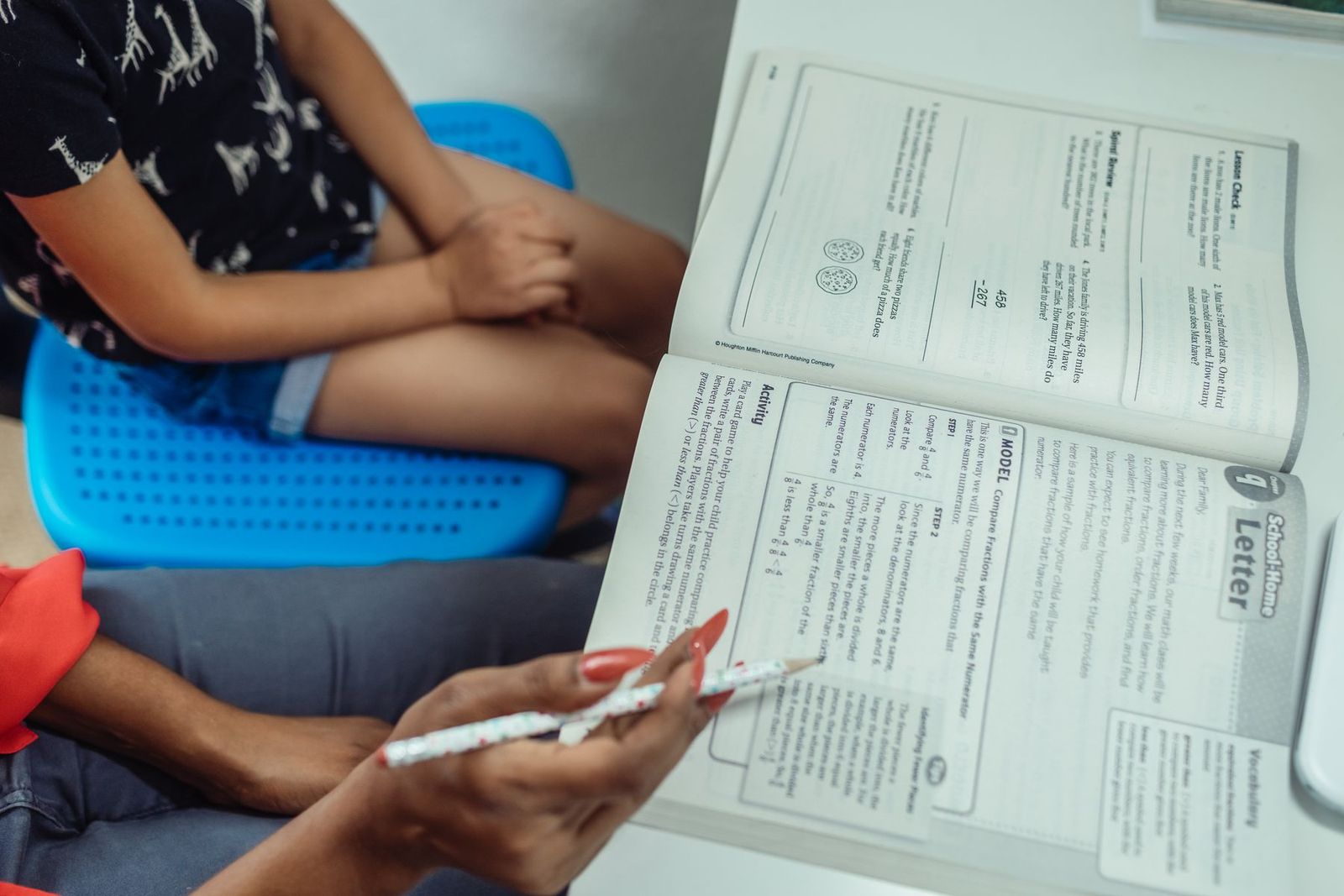 Lehrer führt einen Schüler durch ein Lehrbuch