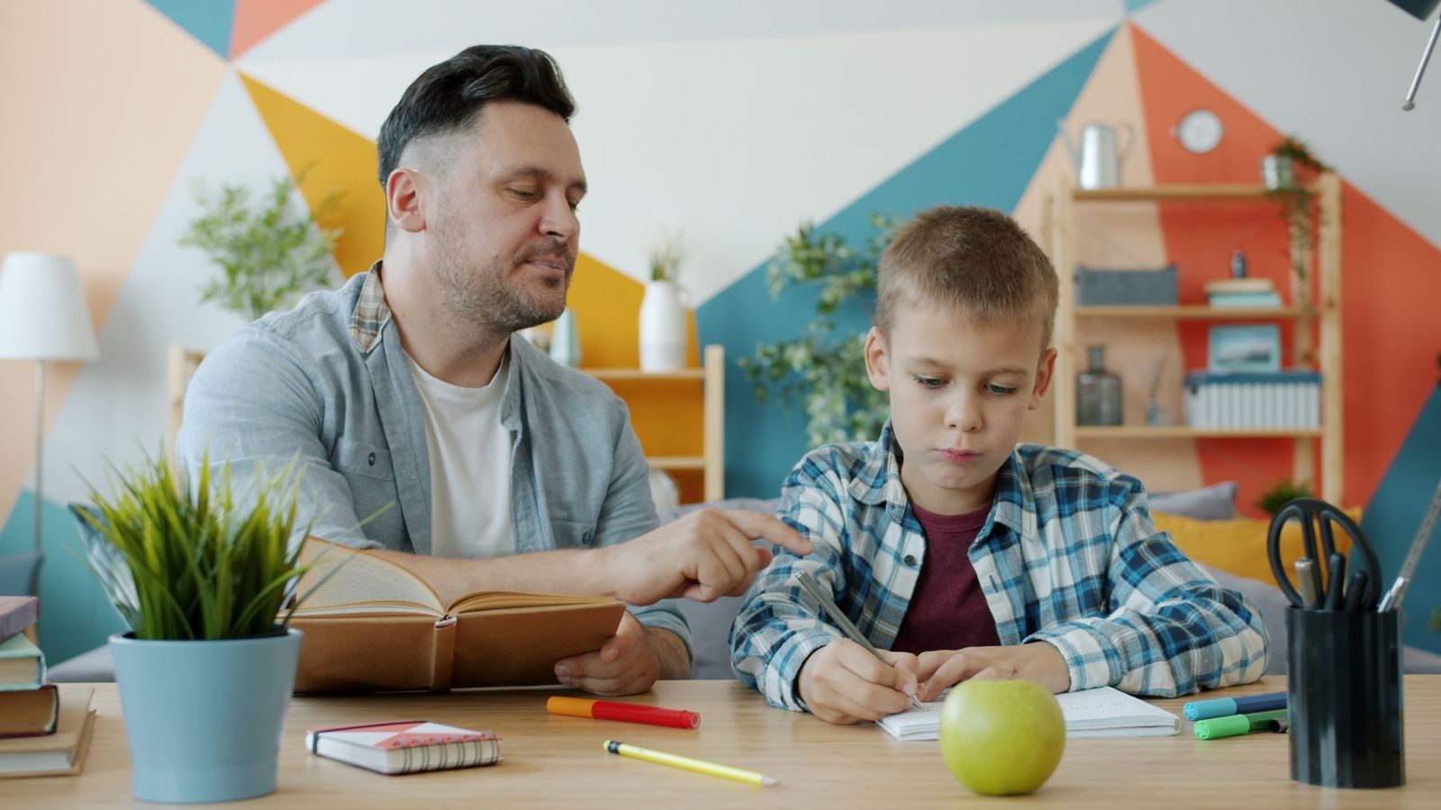 Vater begleitet seinen Sohn bei den Hausaufgaben